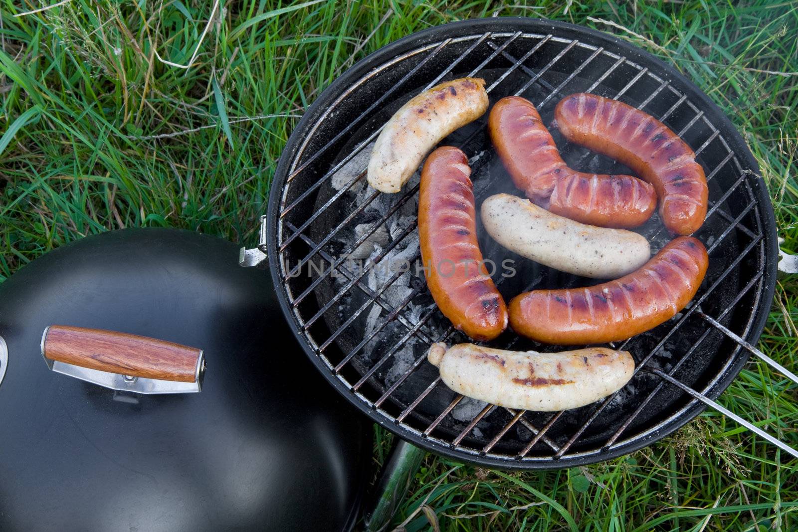 Fresh sliced grilled sausages, outdoor barbecue