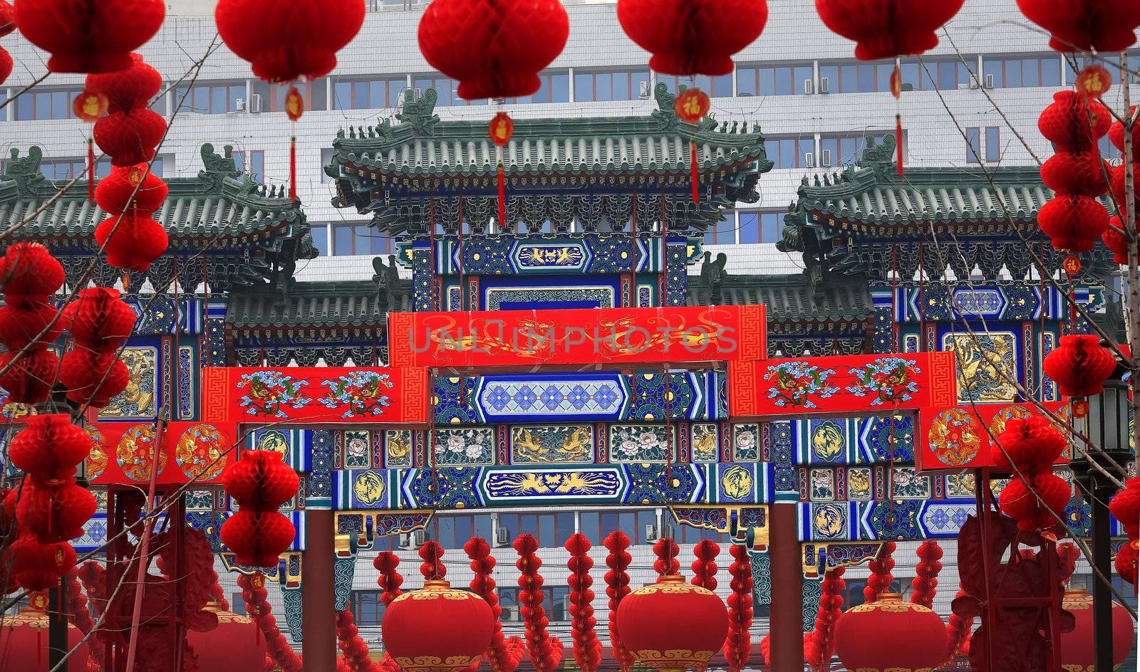 Ornate Chinese Gate Lucky Red Lanterns Chinese New Year Decorations Stone Gate Ditan Park Beijing China.  During Lunar New Year, many parks and temples in China have large outdoor fairs, festivals.  Chinese characters on lanterns say lucky and long life.