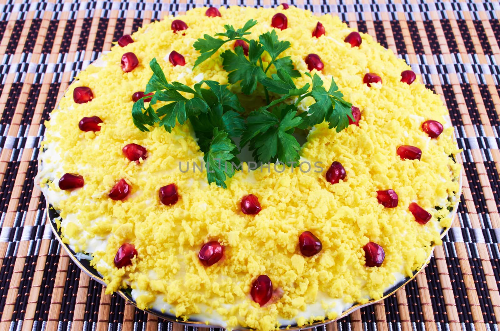 Salad with boiled egg, cream sauce and pomegranate seeds on a plate