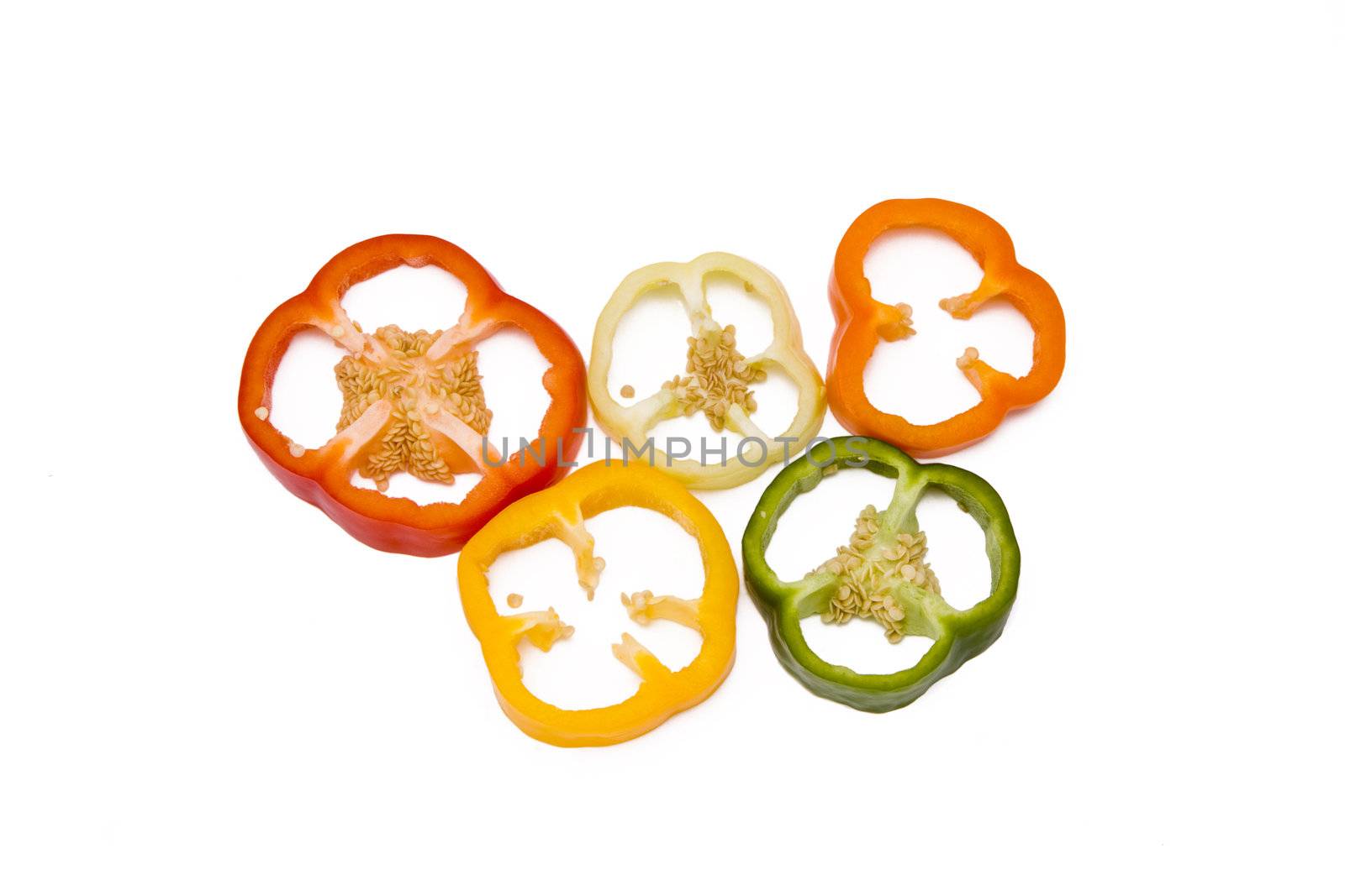 Mixed pieces of different colored paprikas isolated on white, olympic circles