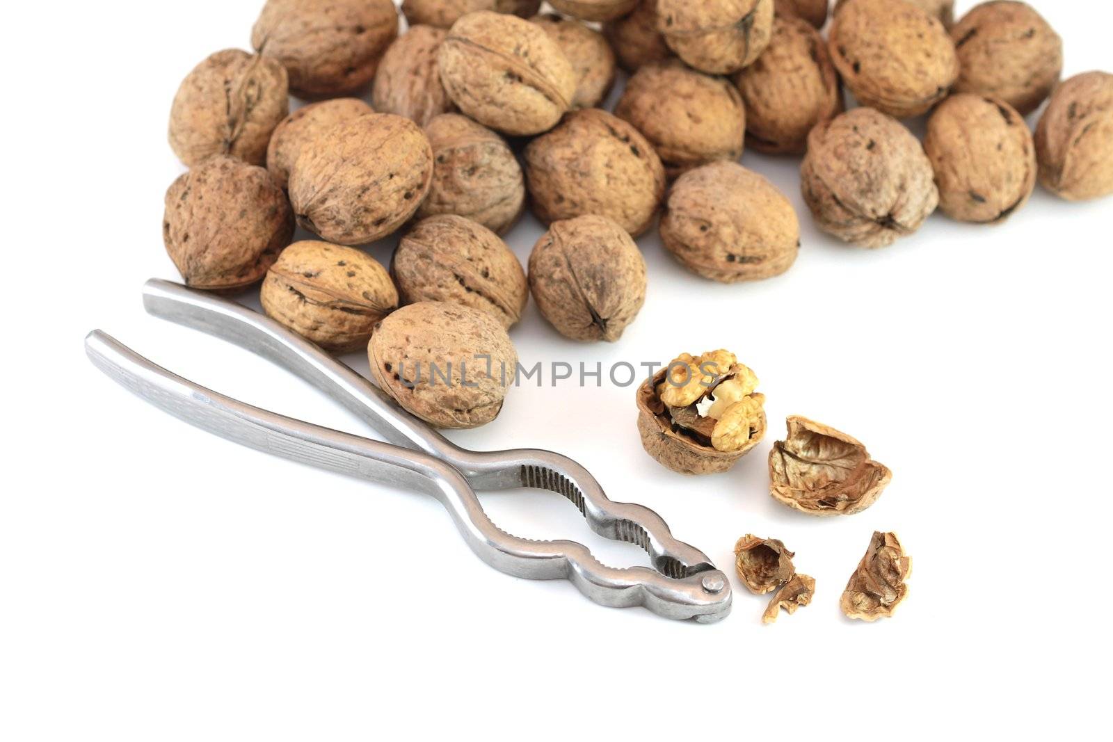 Walnuts with nutcracker isolated on white background
