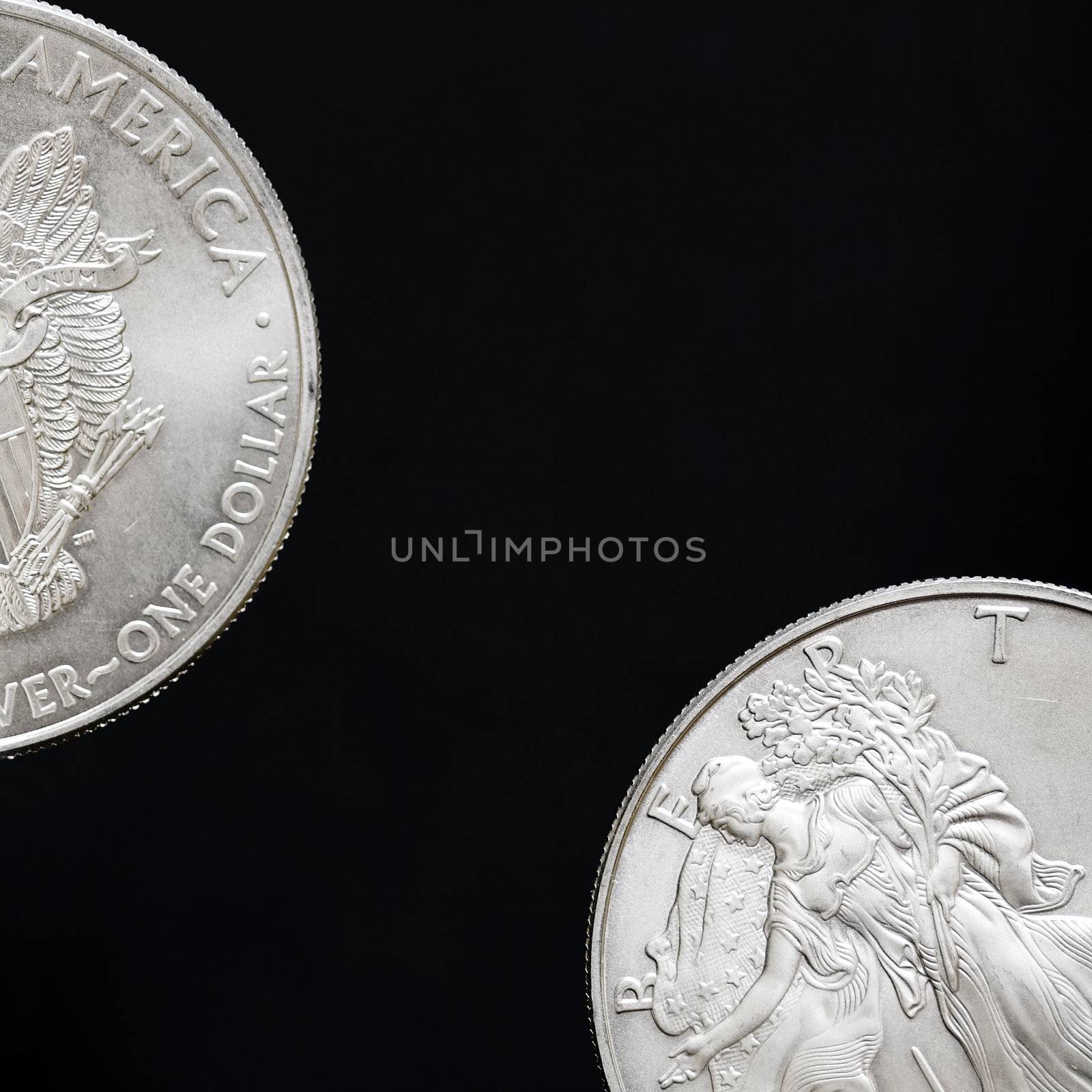 Two silver shiny dollar coins isolated on black background
