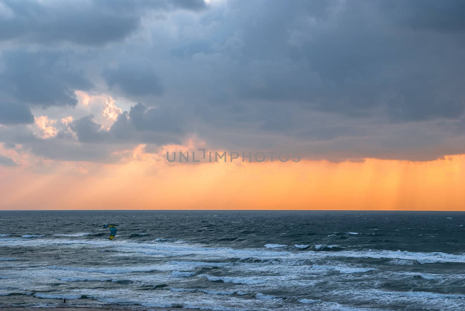 kitesurfing  and storm clouds over the sea