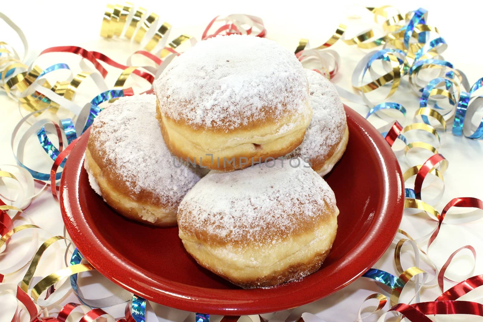 Pancakes with powdered sugar and jam on a plate with paper streamers