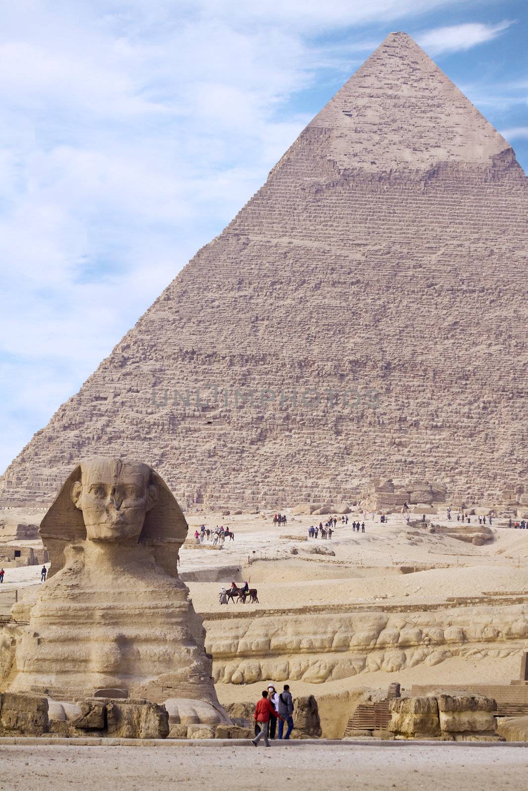Ancient Egyptian Sphinx with old historic pyramid behind