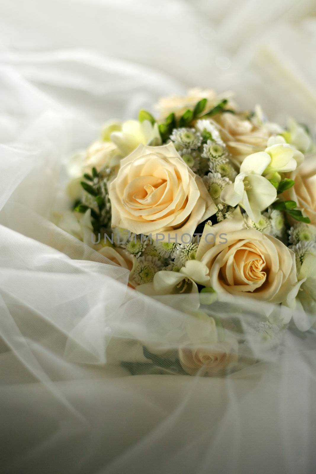 Wedding bouquet from beige roses on a background of a wedding dress