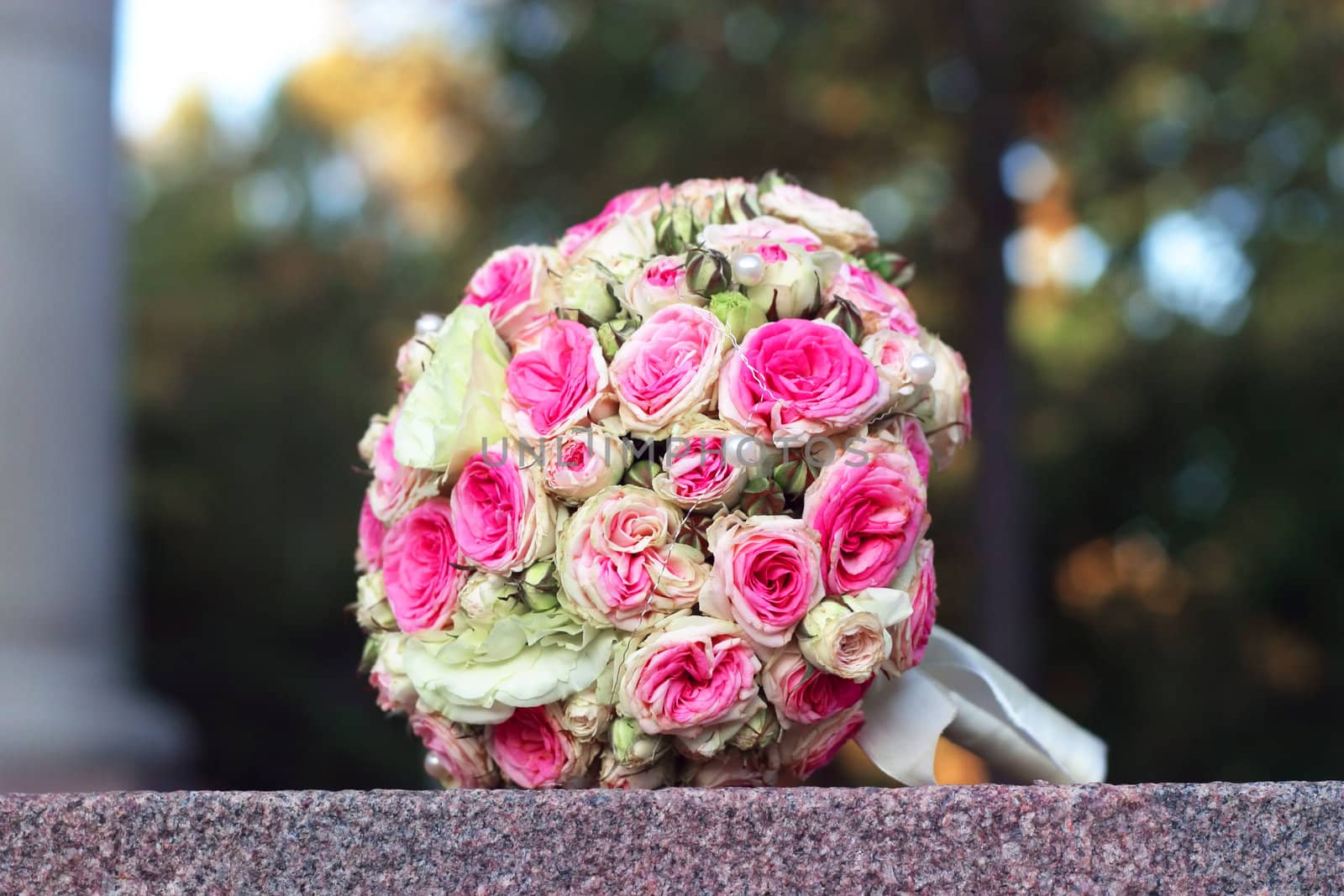The forgotten wedding bouquet from roses lays on a granite stone