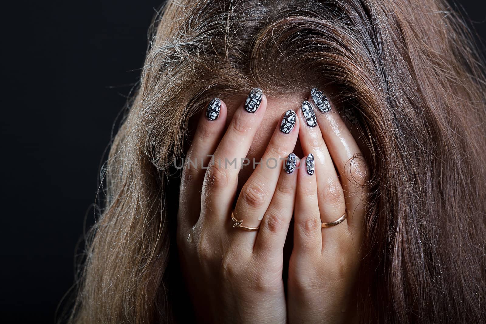 girl with wet hair in despair covers her face