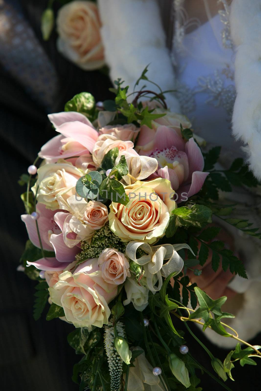 Wedding bouquet from beige roses on a background of a wedding dress