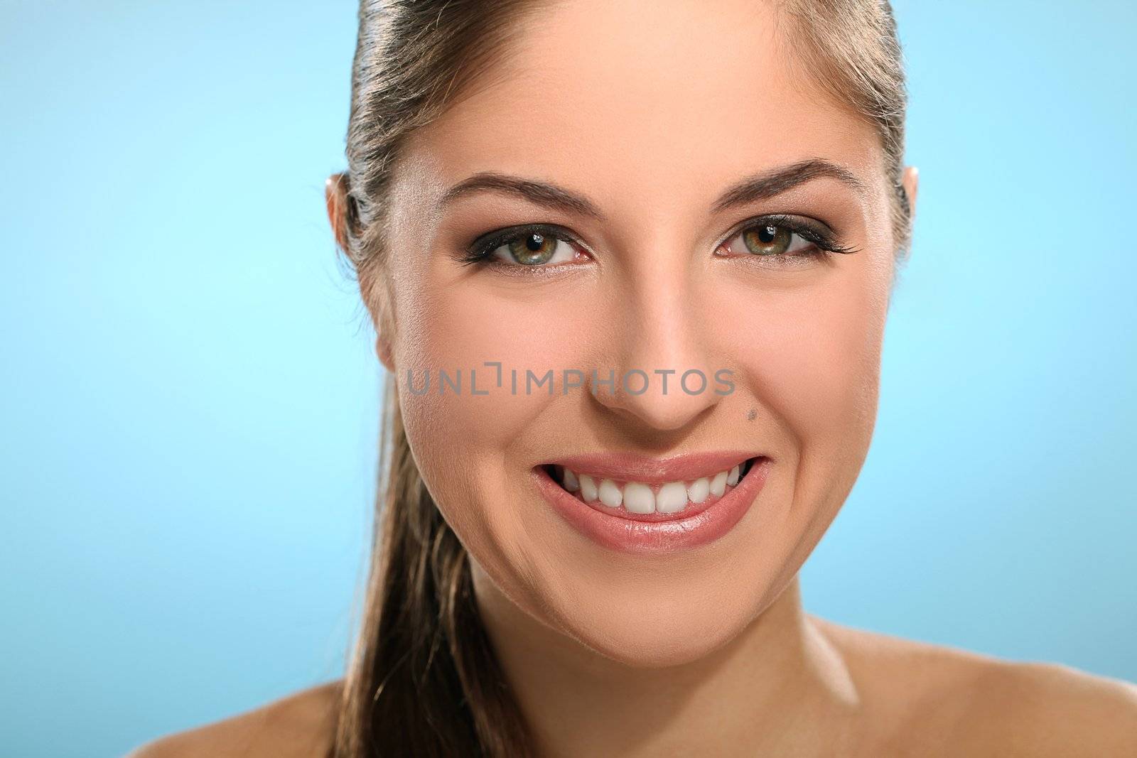 Portrait of young smiling woman isolated over blue background