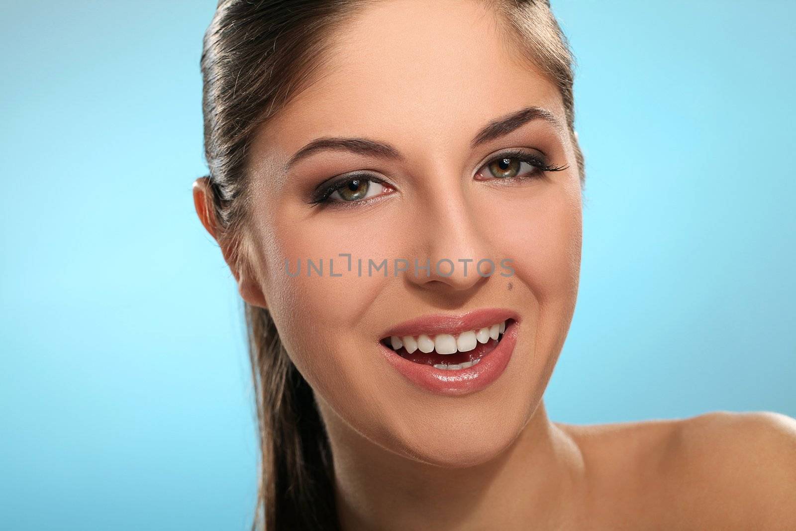 Portrait of young smiling woman isolated over blue background