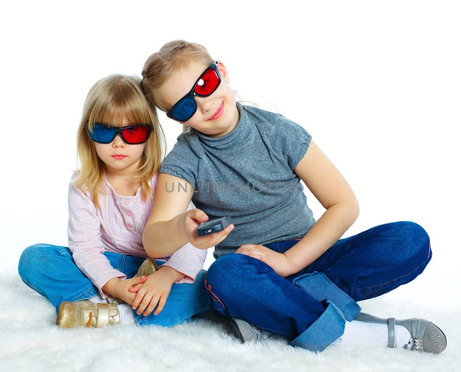 Studio shot of two girls in 3d glasses with control panel watching TV. Isolated white background