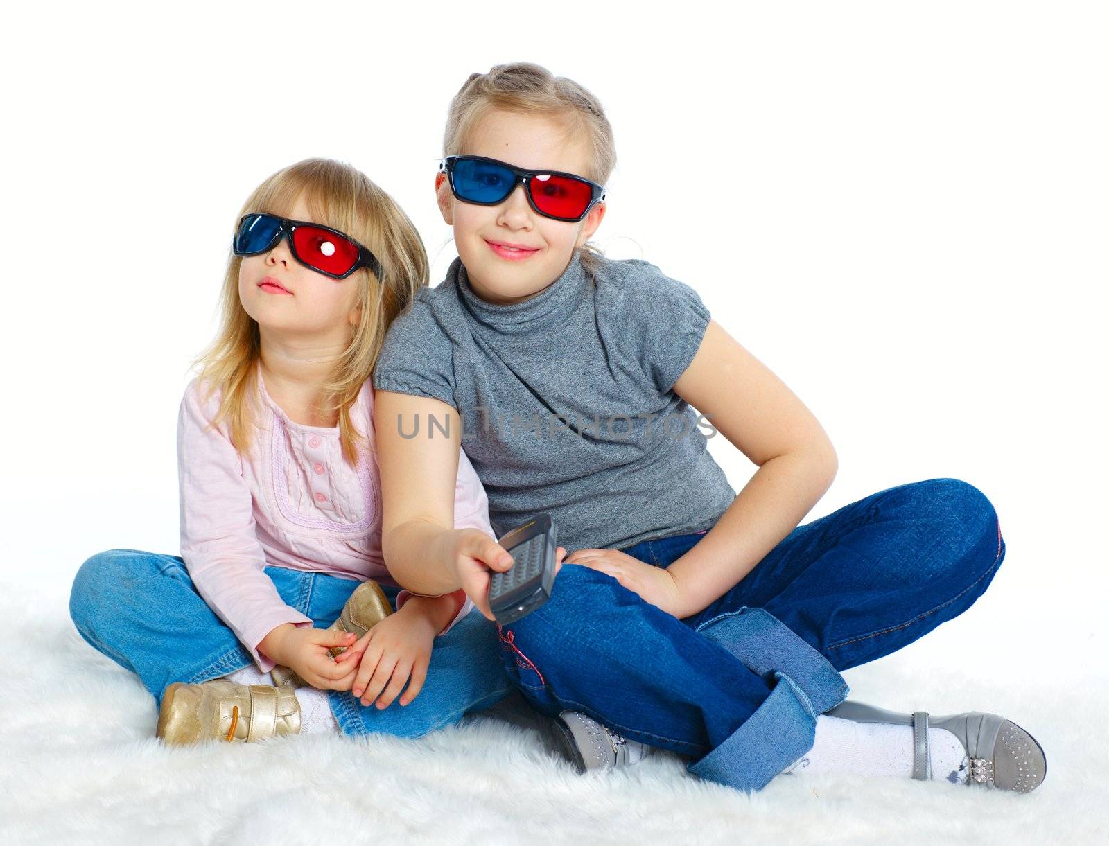 Studio shot of two girls in 3d glasses with control panel watching TV. Isolated white background