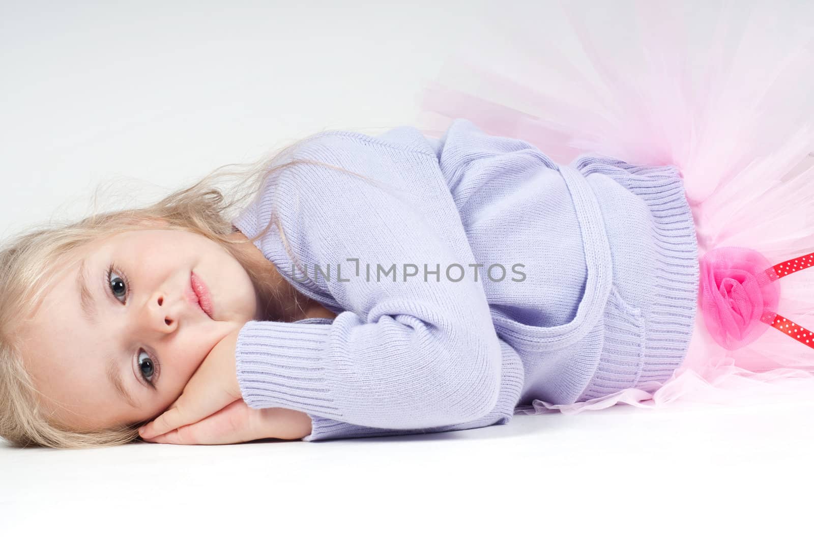 Studio shot of ballet dancer girl lying on the floor