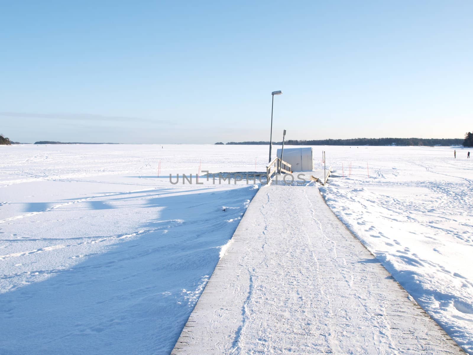 Ice swimming place, pier covered with snow, blue sky