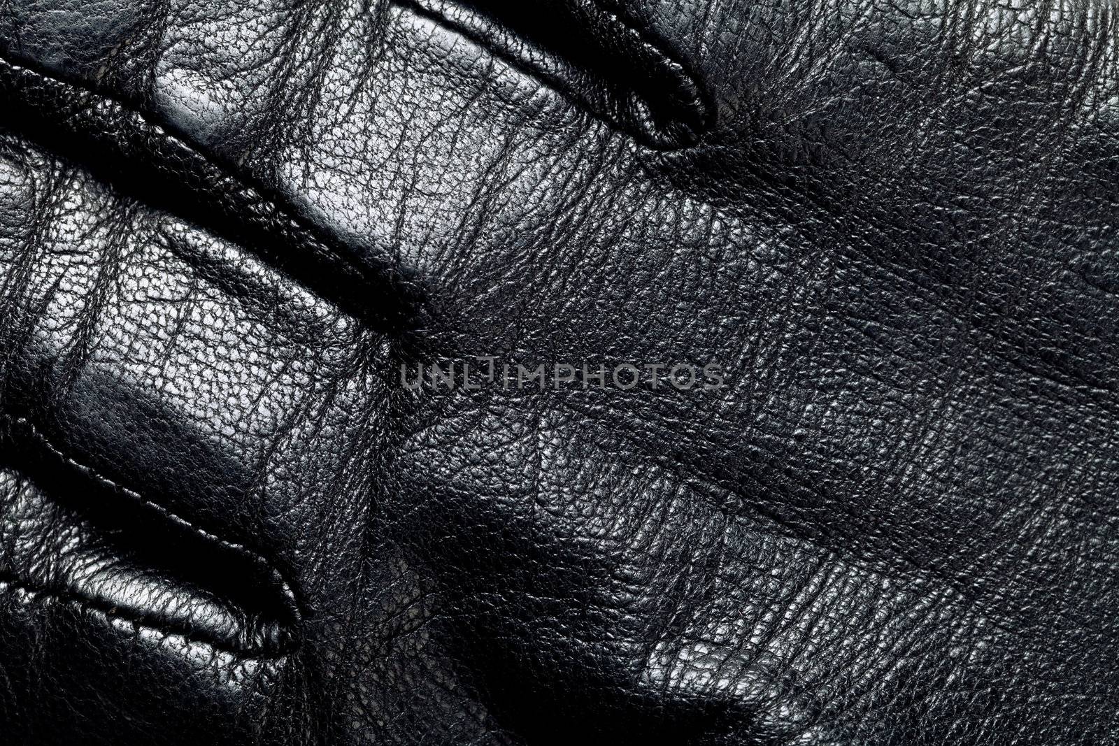 Black leather for background. Man glove. Macro shot
