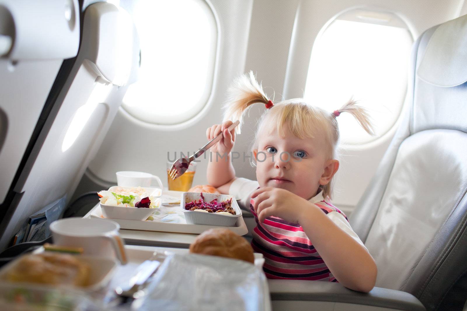 girl eating in the airplane by vsurkov
