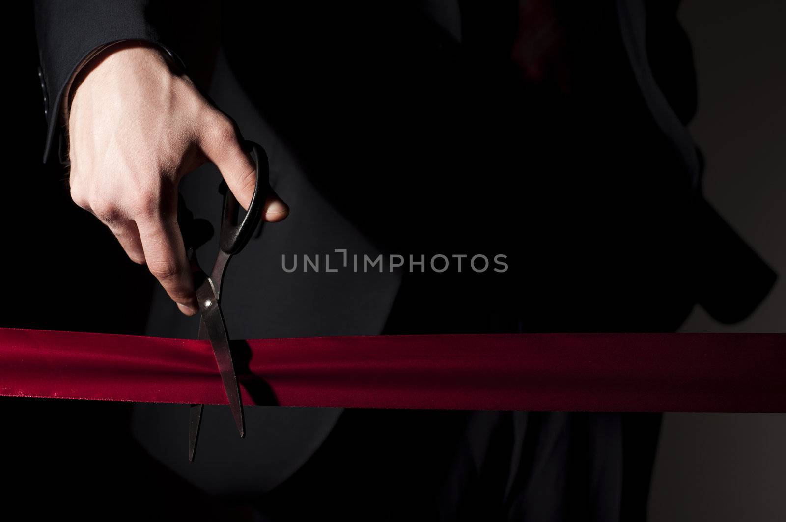 man in a suit, cuts a red tape, opening of event