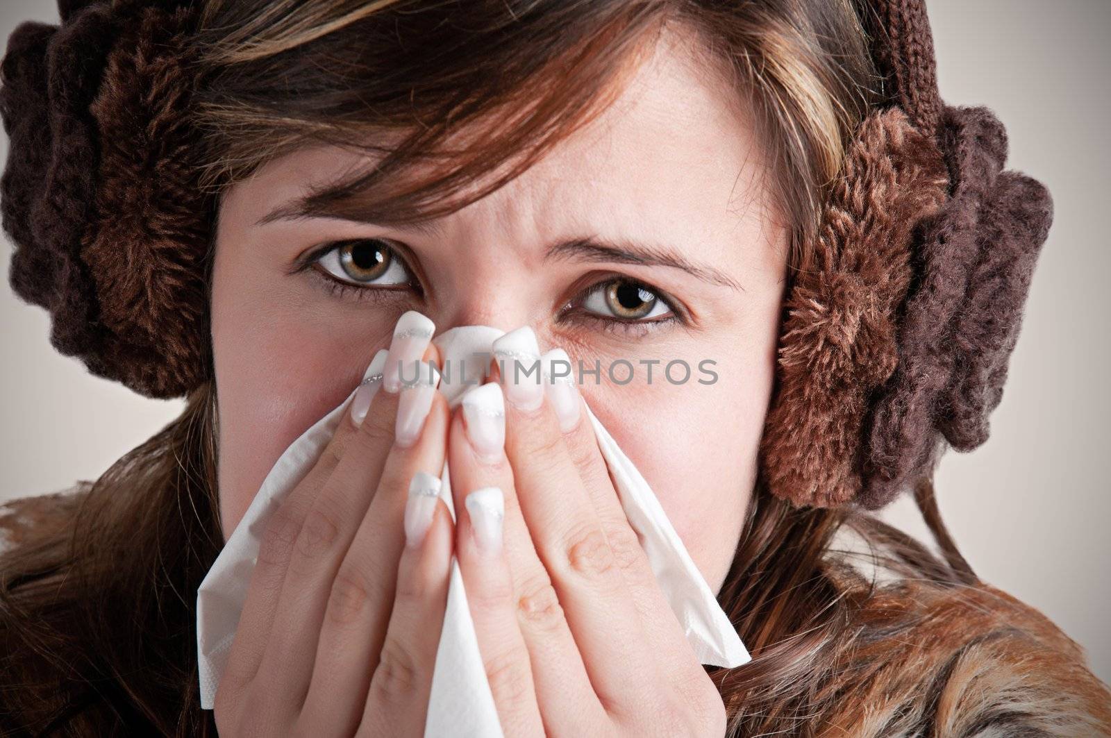 Pale sick woman with a flu, sneezing, in a dark background