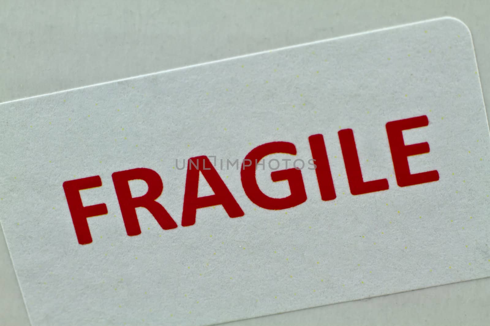 A bold red fragile sticker on the side of a white box.