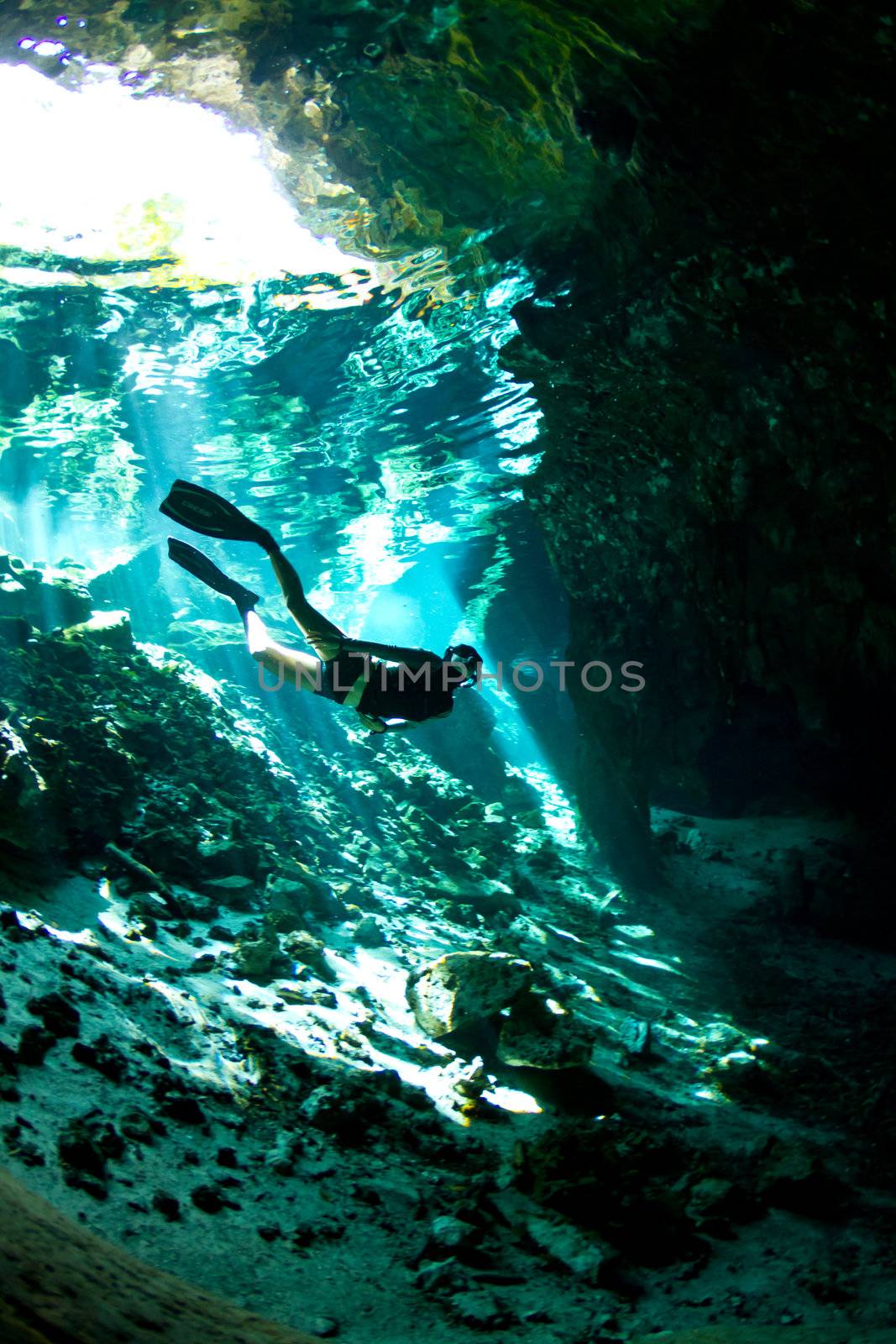 A young woman free dives into a Cenote