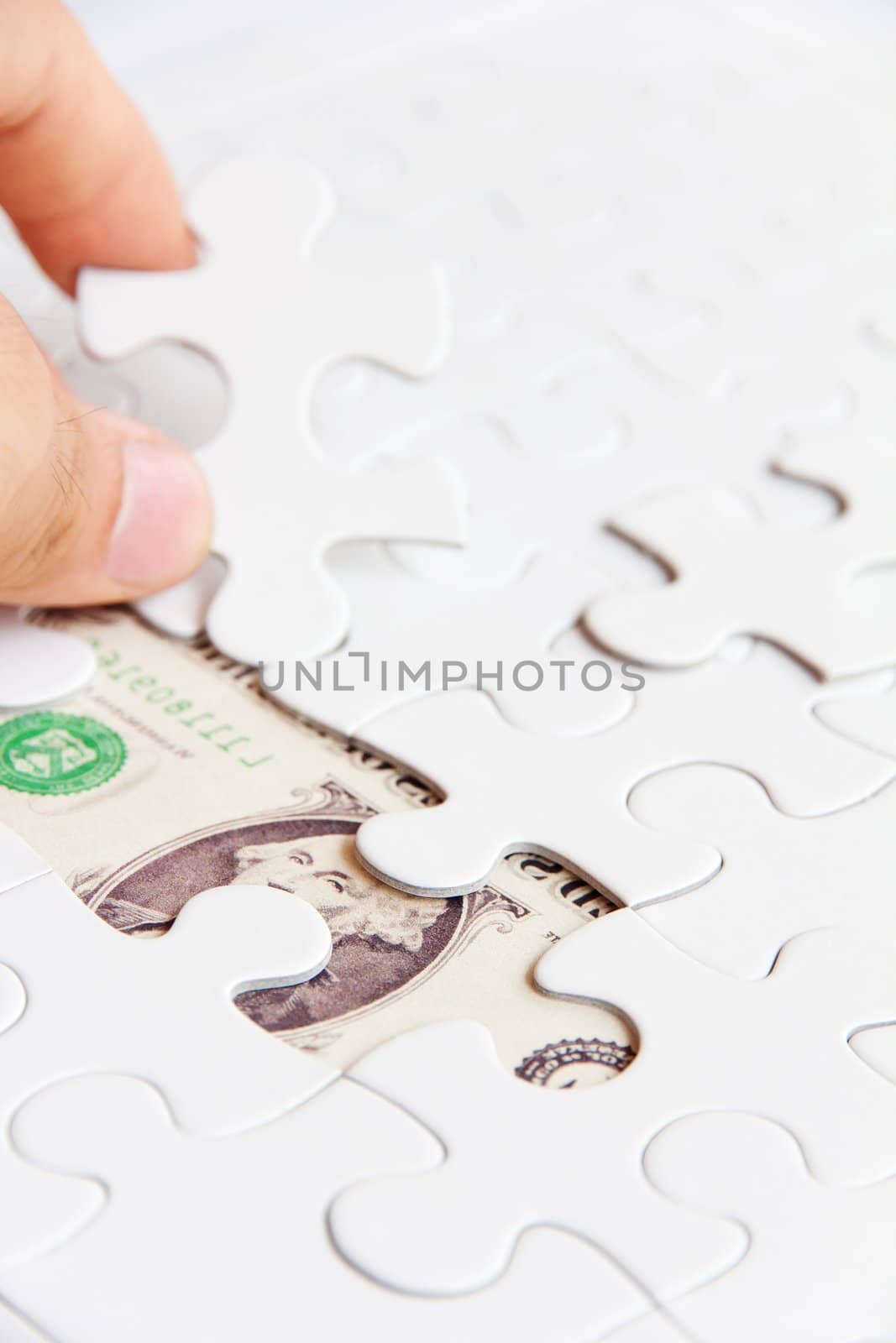 hand holding a puzzle piece, money concept