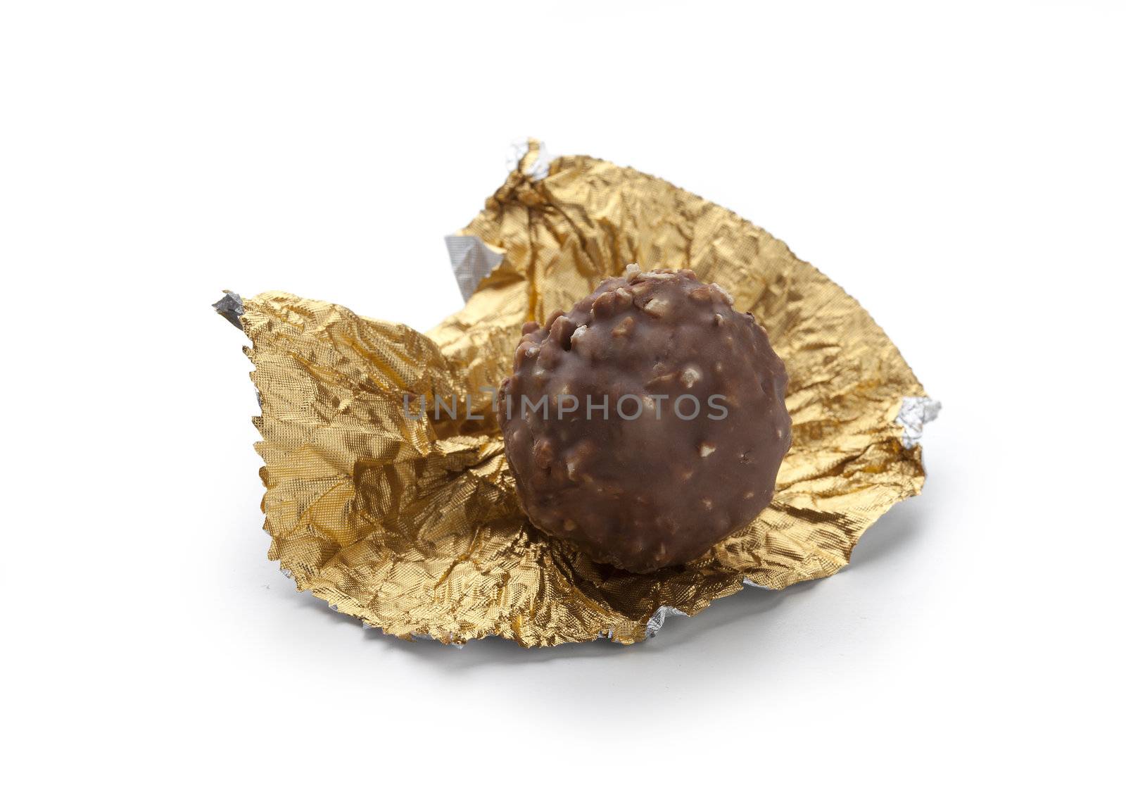 Isolated chocolate candy on the golden foil