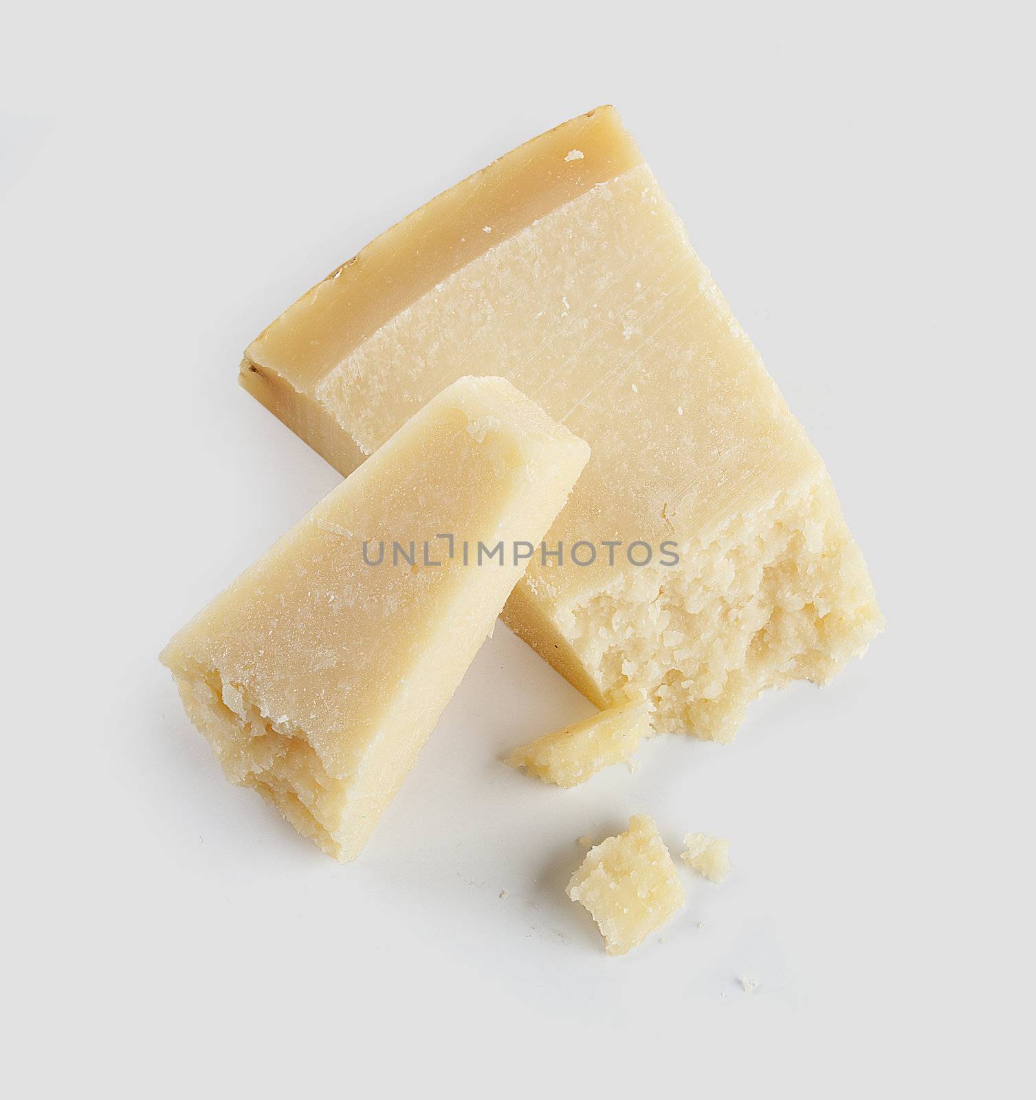 Two pieces of hard cheese on the grey background