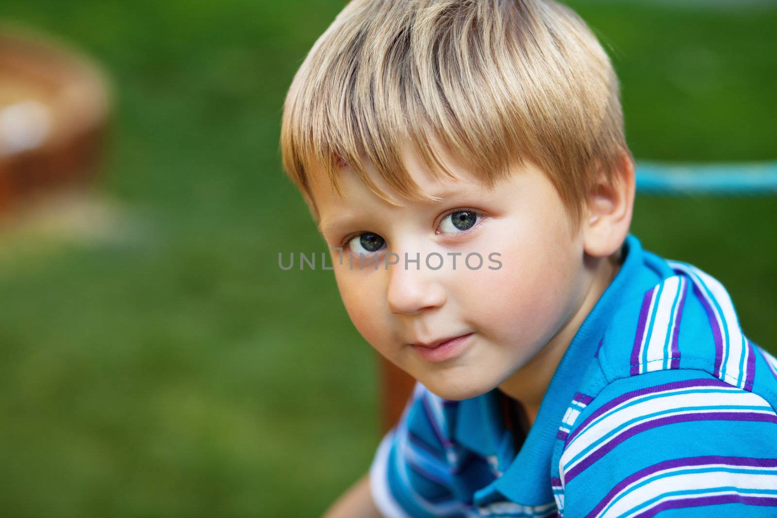 Horizontal outdoor portrait of a cute blond boy