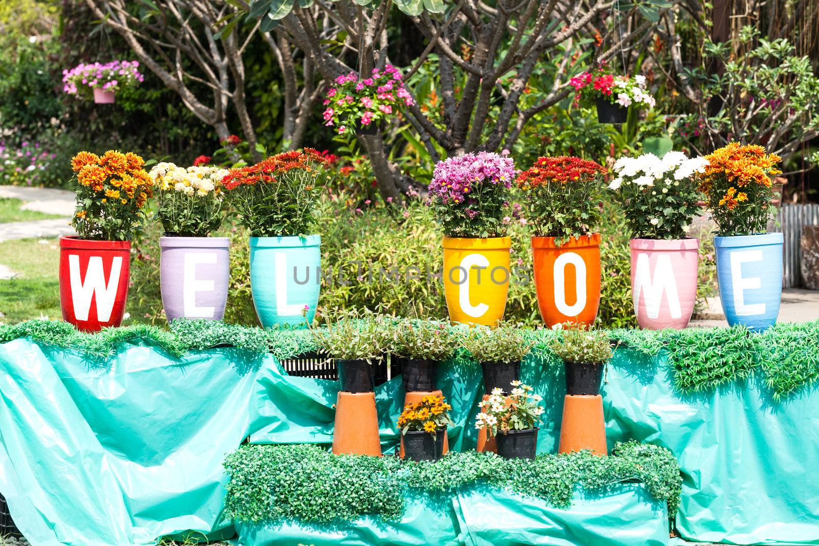 Flower clay pot and painting that welcome message in the garden.