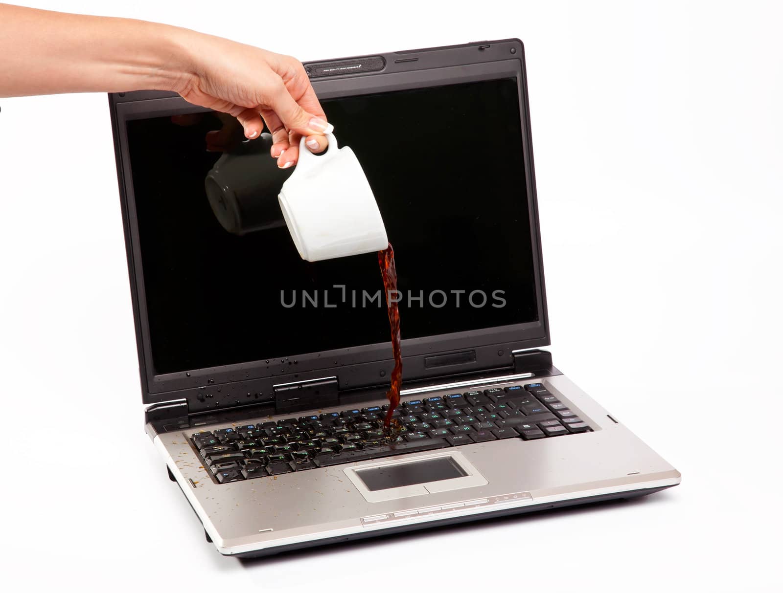 Coffee spilled on laptop keyboard on white background