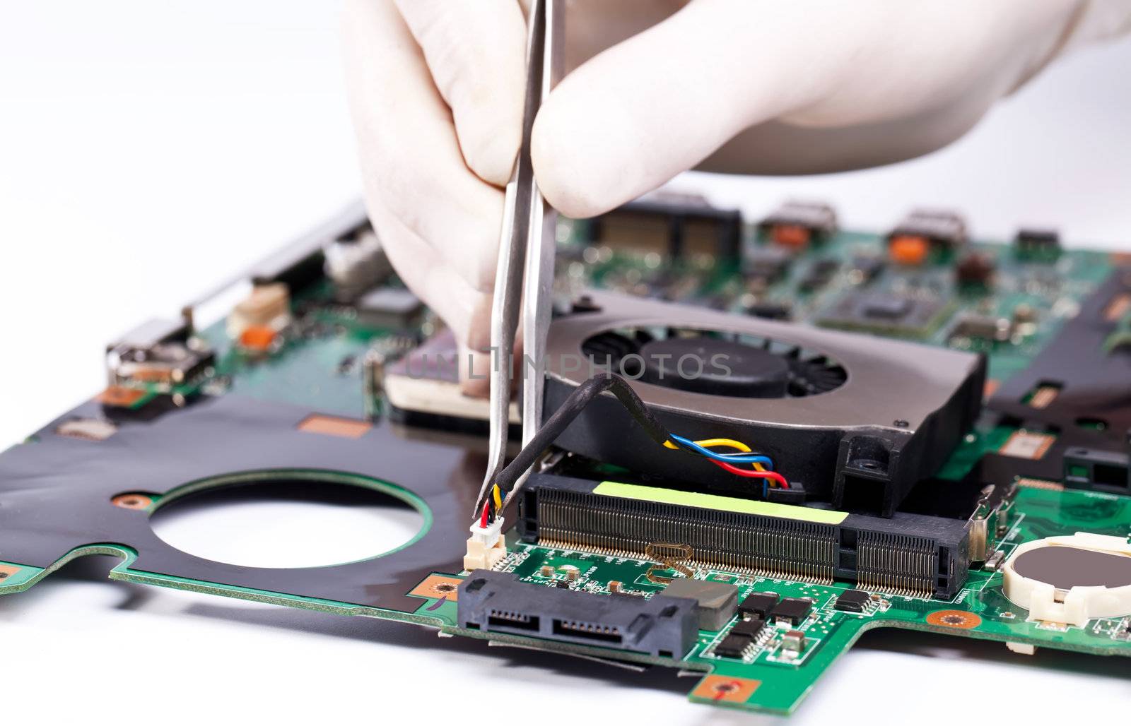 Man in white gloves Installing laptop fan with tweezers