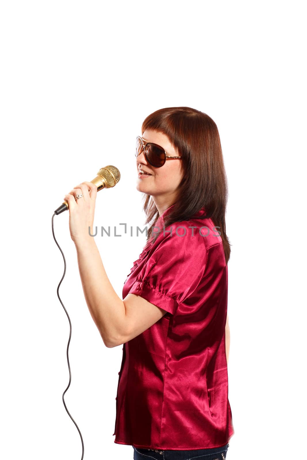 Woman with big sunglasses singing into a microphone