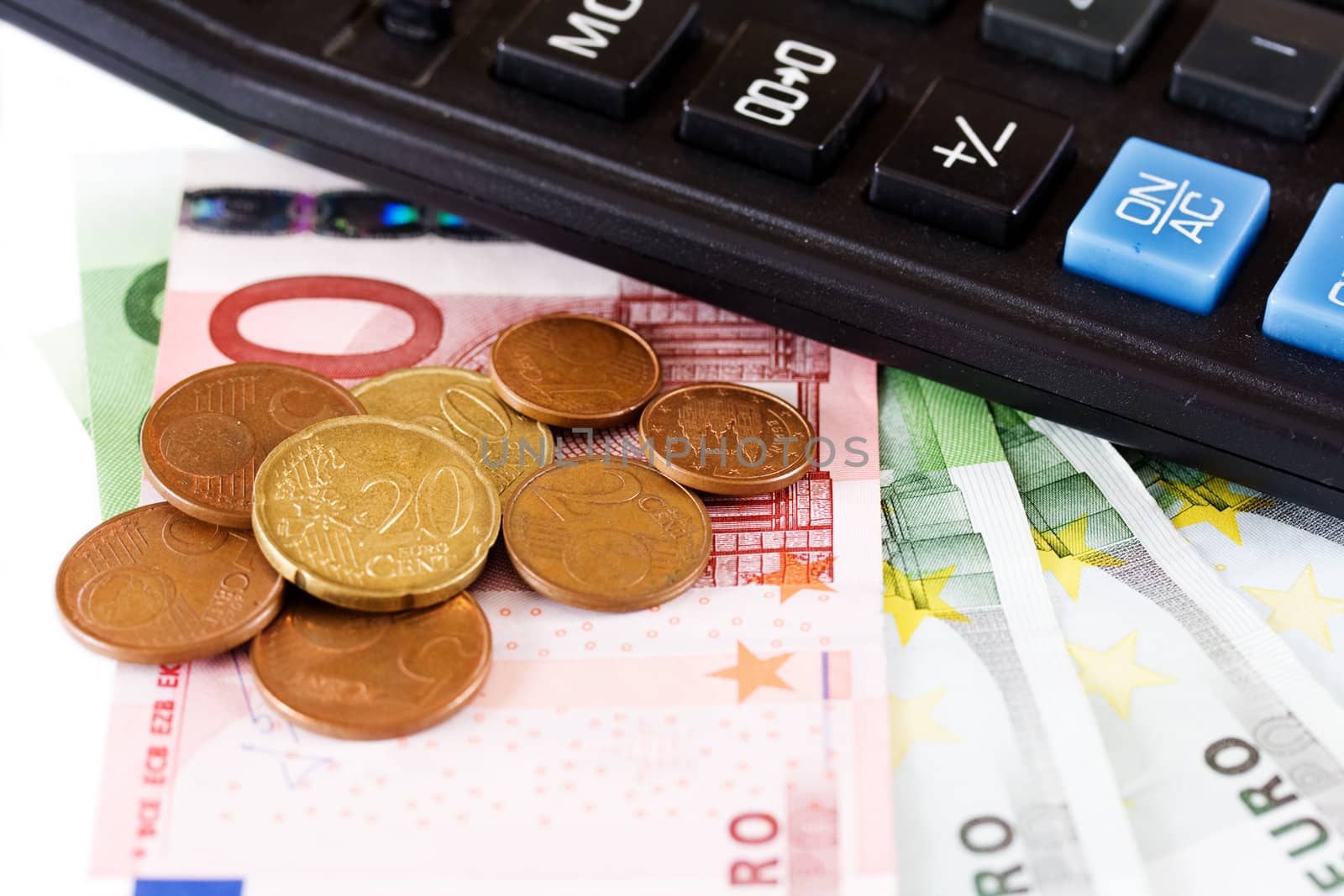 Euro coins and banknotes with a calculator isolated on white background