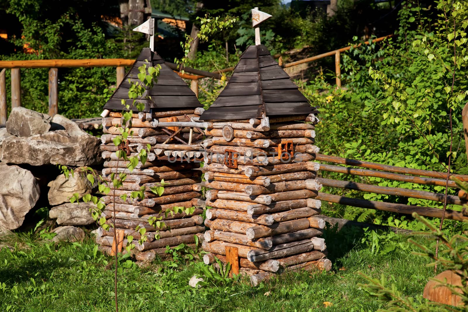 Miniature wooden towers in forest in summer