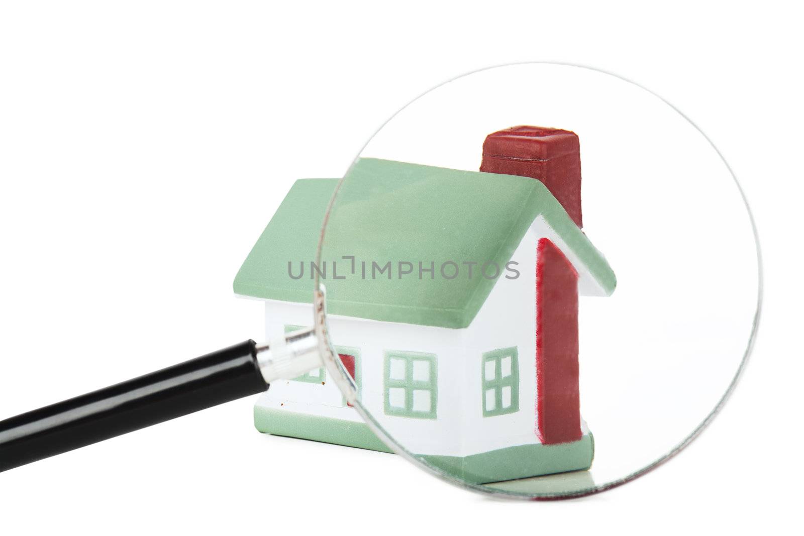 Toy of house and hand with magnifying glass isolated over white background
