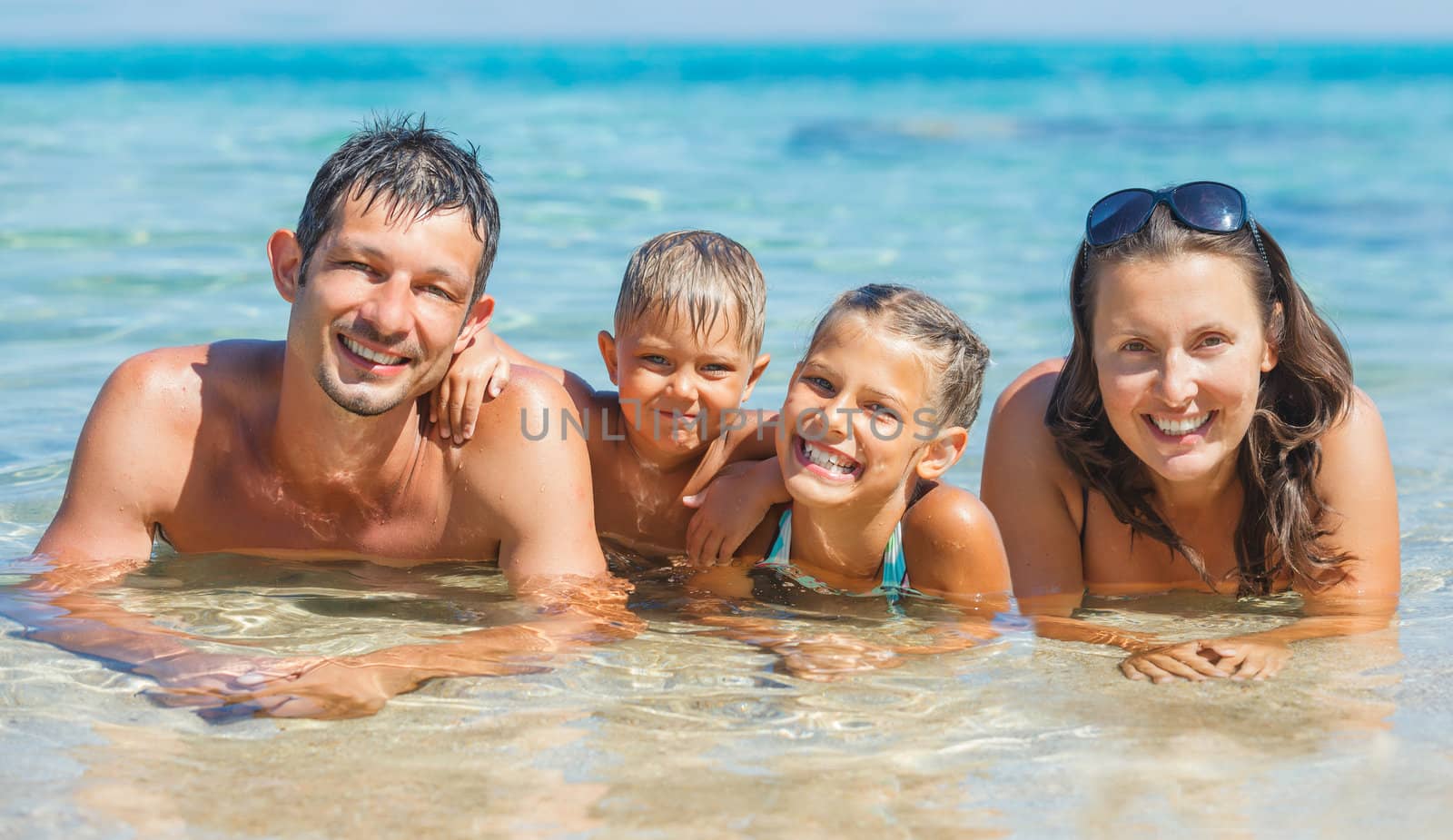 Happy family playing together in the transparent sea