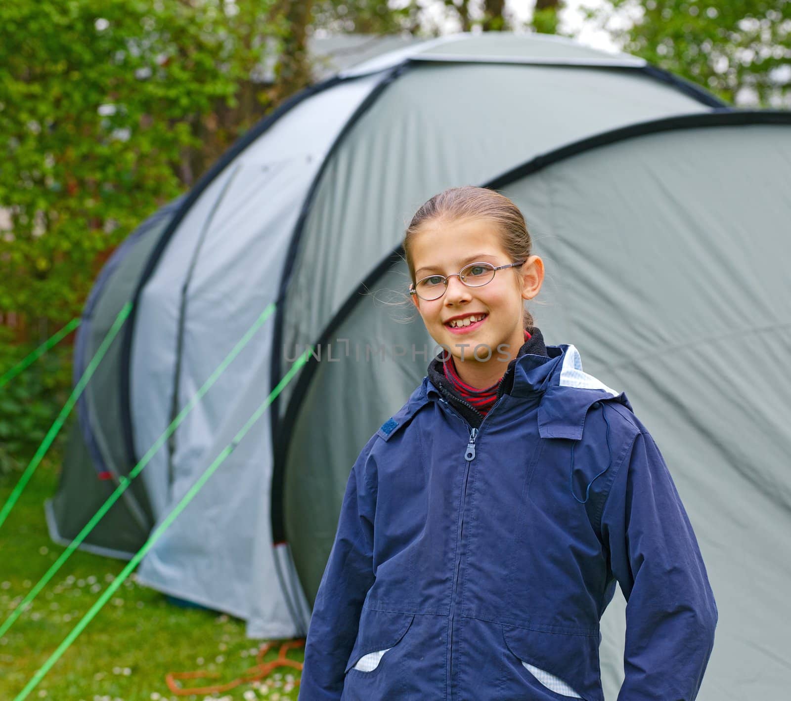 Young girl out camping learning how to pitch tent