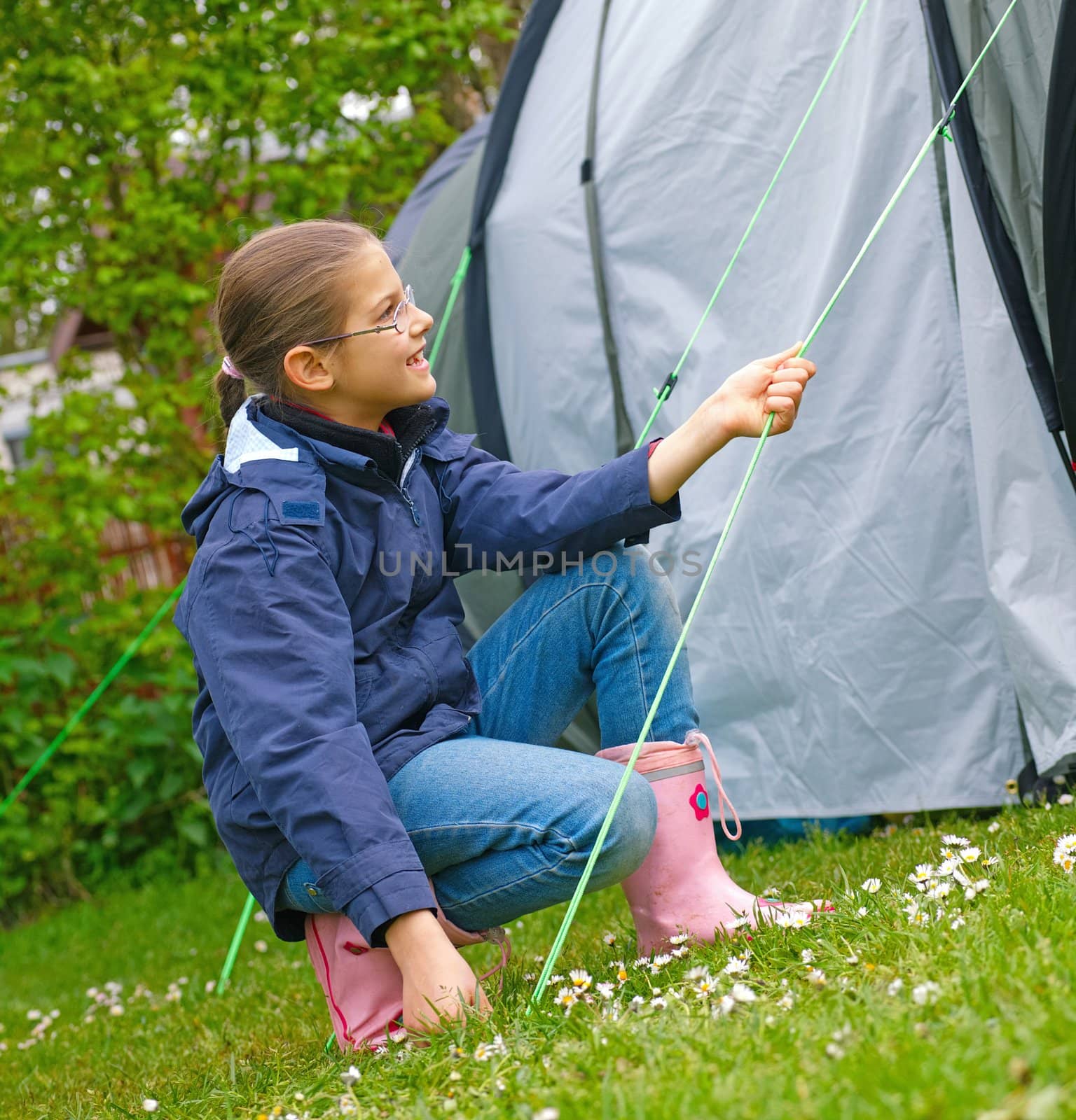 Young girl out camping learning how to pitch tent