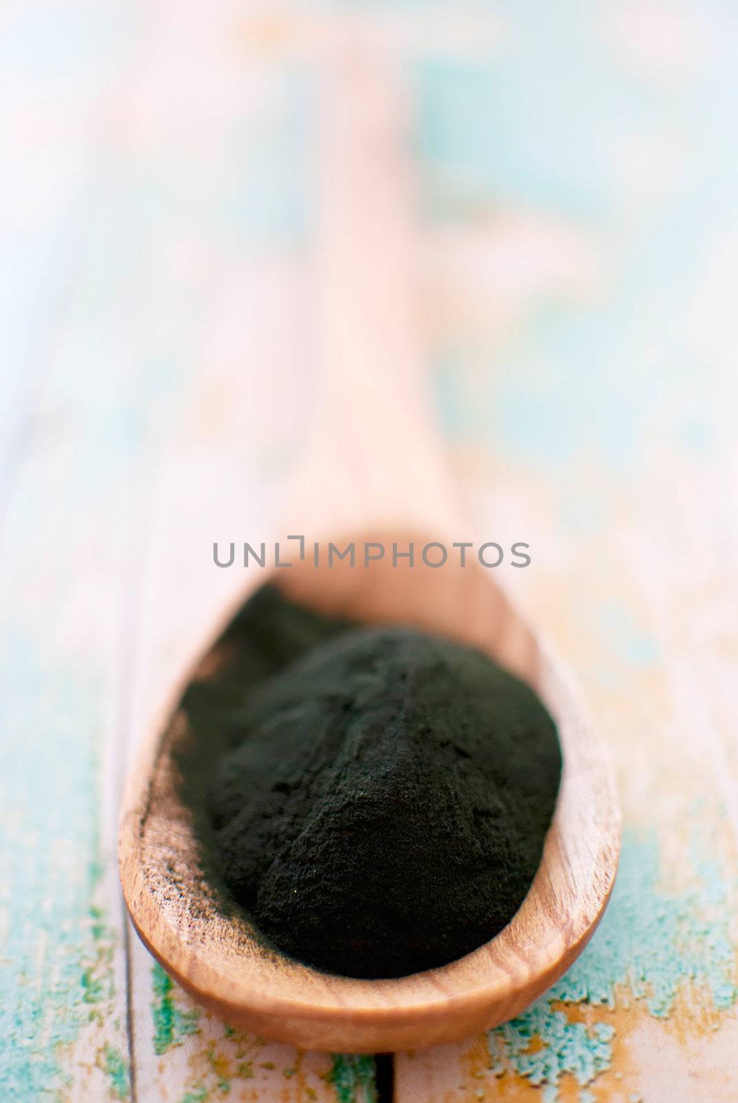 organic spirulina algae powder in wooden spoon