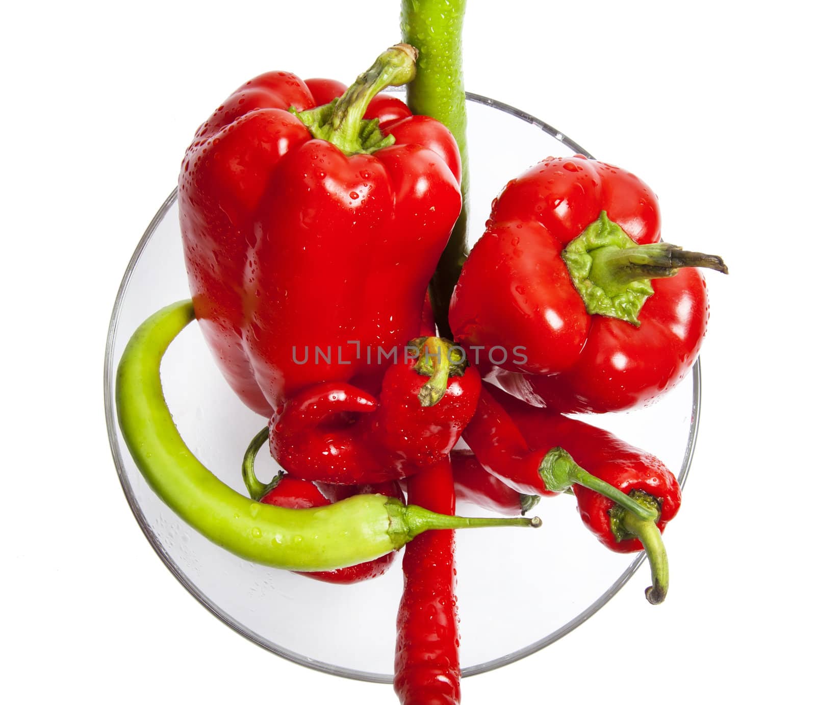 Red and green chili and bulgarian pepper in glass dish by RawGroup