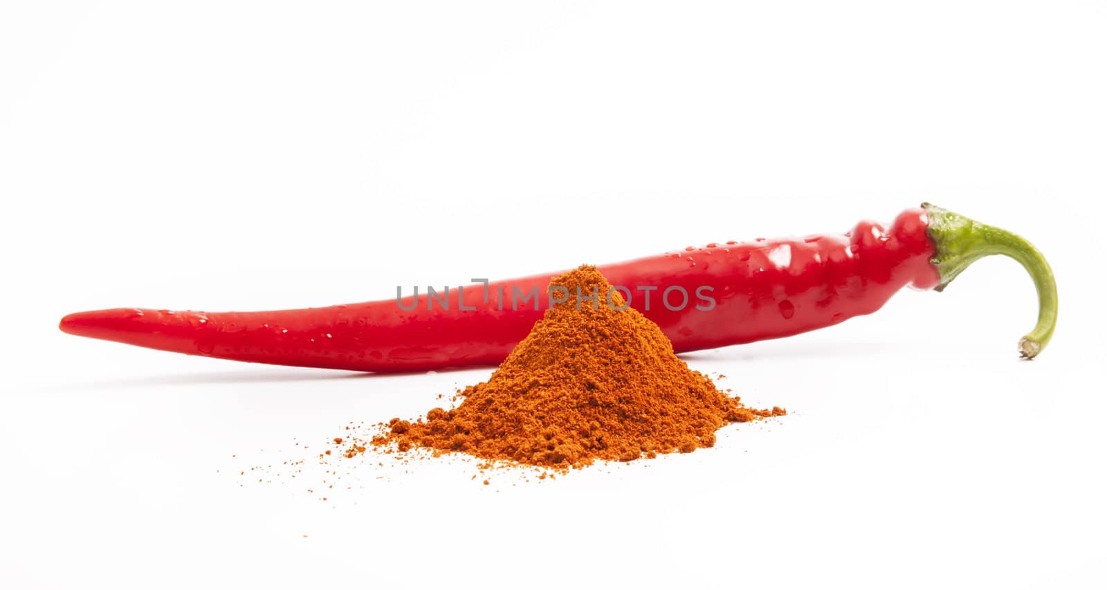 Red chili pepper and pile of paprika spice on white background