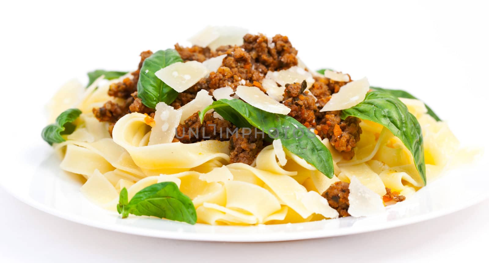 Spaghetti carbonara on white plate with basil