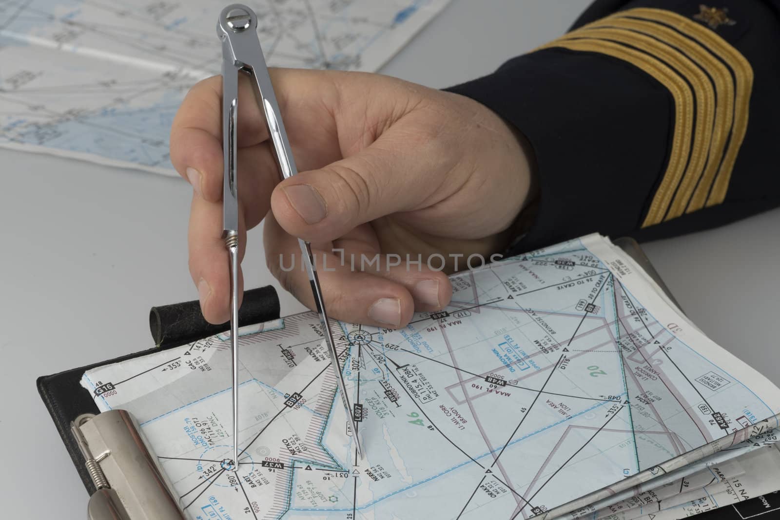 Hand of Captain using a pair of compasses for navigation purpose
