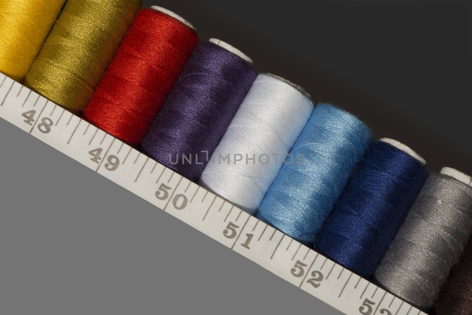 spools of thread of different colours and a tailor's measuring tape