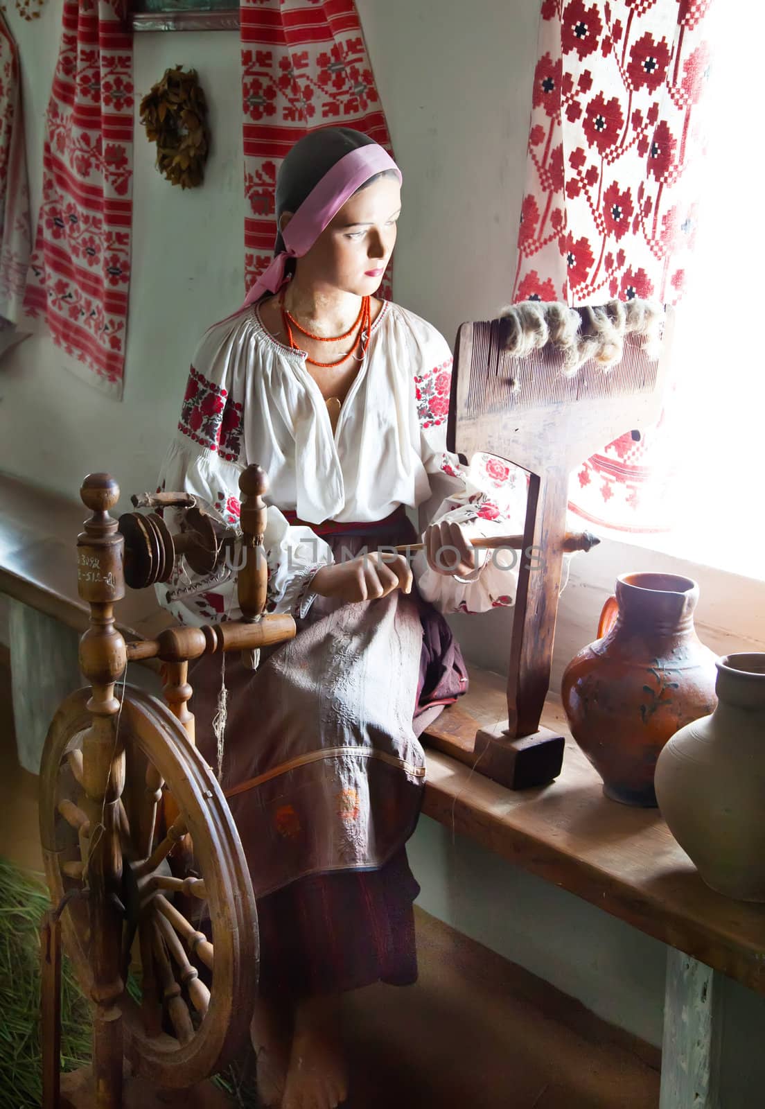 Ukrainian girl waxwork working in traditional interior