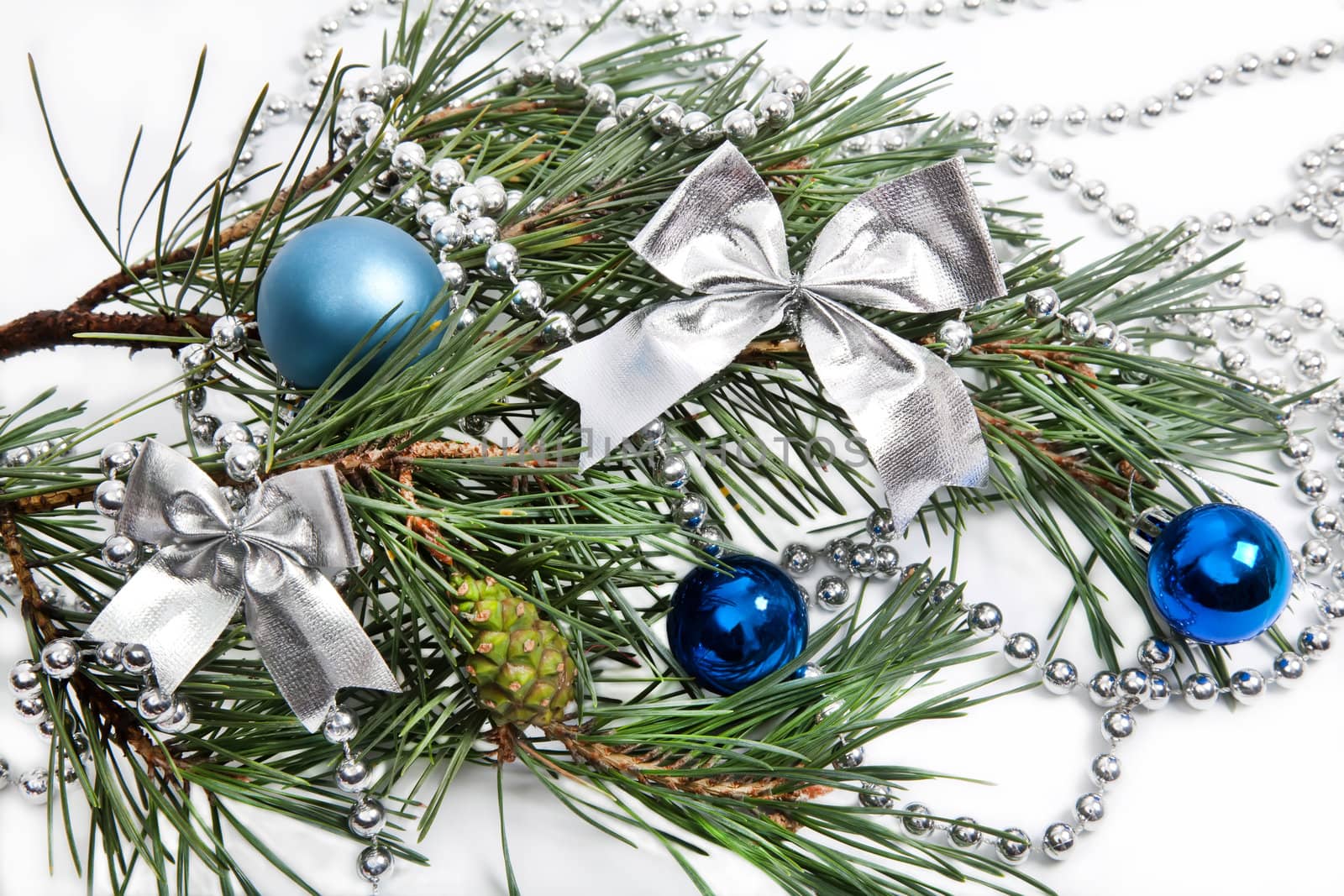Christmas decorations with blue balls and silver beads on white background