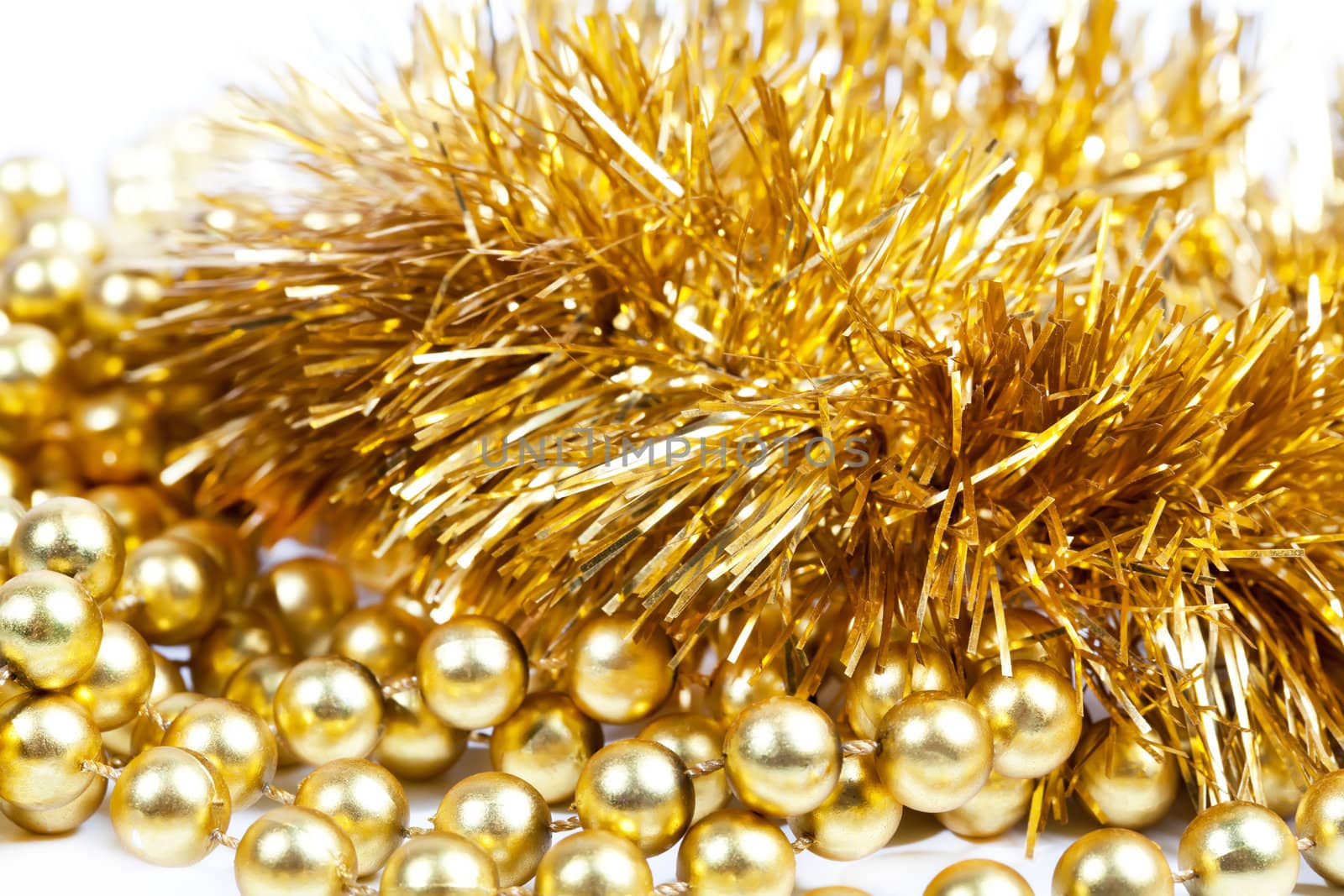 Golden tinsel and beads on white background