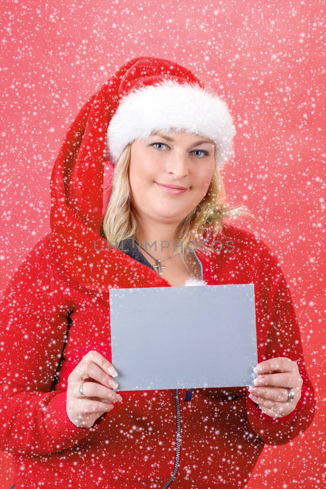 Joyful pretty woman in red santa claus hat smiling on red background