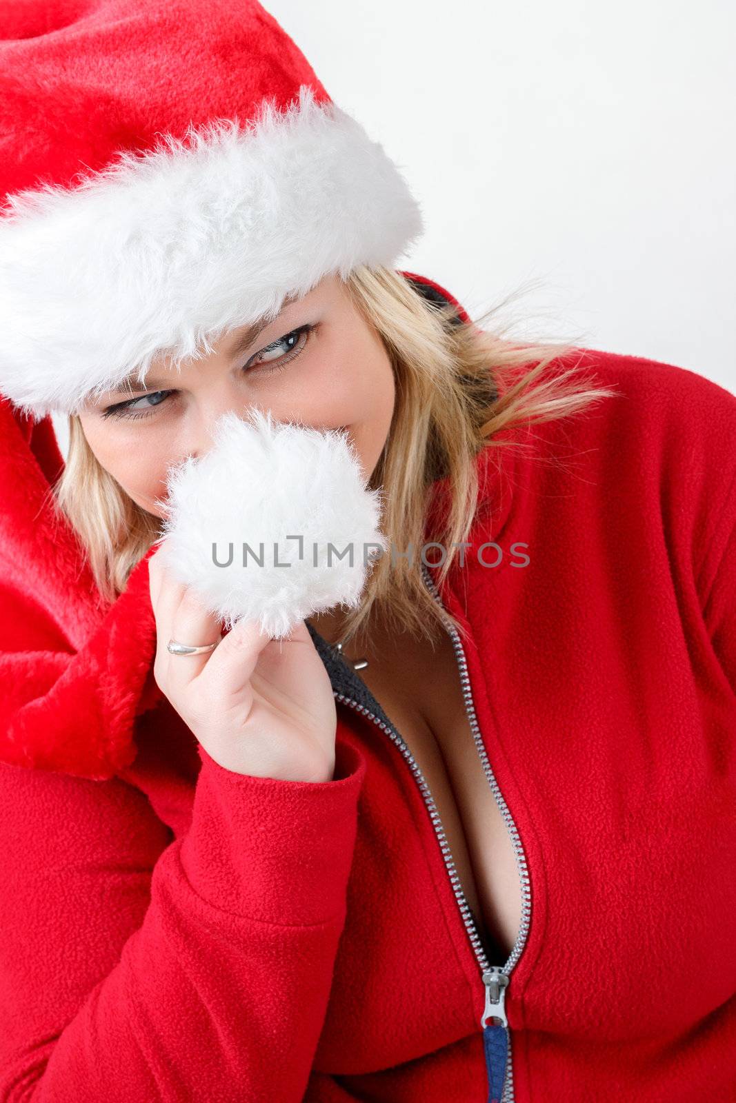 Portrait of joyful pretty woman in red santa claus hat smiling on white background